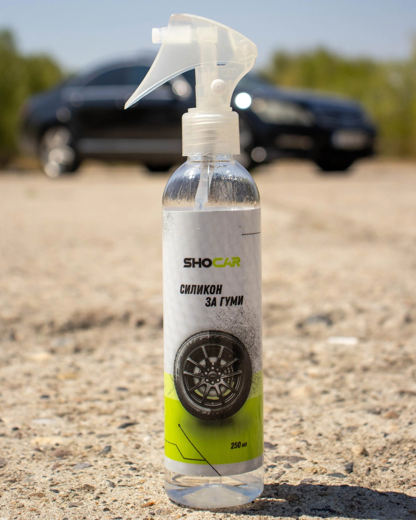 Bottle of SHOCAR tire cleaner with a blurred car in the background