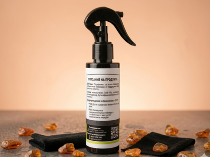 Black spray bottle with a label on a wooden surface with amber-colored stones.